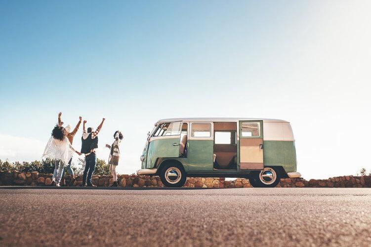 A family having fun on a roadtrip next to a camper van